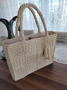 a handbag sitting on top of a wooden table next to a vase and doily