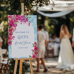 a welcome sign for the bride and groom at a wedding reception with guests in the background