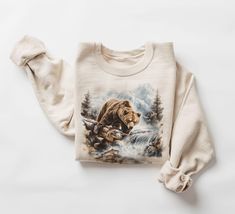 Retro Grizzly Bear Fishing In Creek Sweatshirt - 90s Vintage Brown Bear Alaska Trout Fish Outfit - Boho Unisex Crewneck Sweatshirt   Our crewneck sweatshirts are beautiful, soft, and comfortable midweight sweatshirts. The kind of sweatshirt you won't want to take off, we promise we won't tell if you wear it multiple days in a row! These sweatshirts are hand printed with a professional garment printer known as DTG for a soft, durable, long-lasting, printed graphic using high-quality water-based ECO inks. Gildan is generally the brand we use but sometimes we have to substitute for Jerzees, Port& CO, and Hanes ECO Sweatshirt blanks. depending on supply shortages. All of the brands are equally great sweatshirts that are super soft inside and almost identical in both feel and sizing. Our sweats Wilderness Outfit, Fish Outfit, Alaska Outfits, Bear Fishing, Trout Fish, Horse Sweatshirts, Outfit Boho, Bear Sweater, Pull Oversize