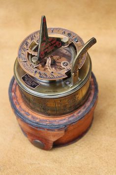 an old fashioned compass sitting on top of a wooden box