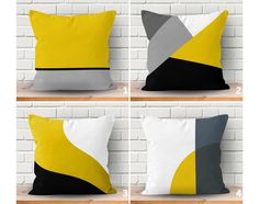 four pillows with different colors on them in front of a white brick wall and floor