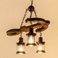 an old fashioned light fixture with three hanging lights