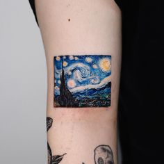 a person with a tattoo on their arm has a starry night painting behind it