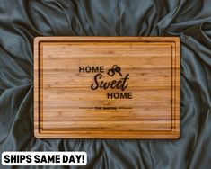 a bamboo cutting board with the words home sweet home on it and a black background