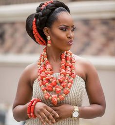 a woman in a white dress with orange beads on her necklace