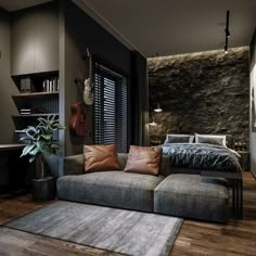 a living room with a couch, table and bookshelf next to a stone wall