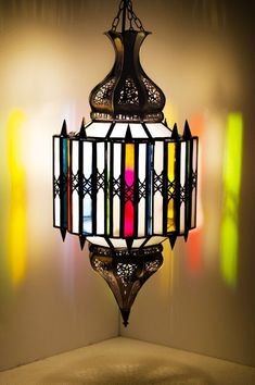 a chandelier hanging from the ceiling with multicolored glass panels on it