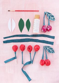 paper flowers and other crafting supplies laid out on a pink surface