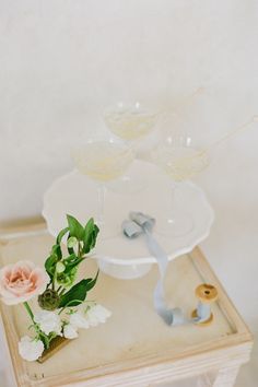 there are three glasses on the table with flowers