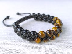 "Tiger's Eye and Onyx Bracelet: Crafted with genuine tiger's eye and onyx gemstone beads, this natural healing crystal jewelry is perfect for men and women. All of the bracelets are personally handmade by me. I carefully select and use genuine natural stones and strong cords to create durable and beautiful pieces. Each piece is made to order and can be customized according to your preferences! Product Details - Handcrafted bracelet featuring 8mm tiger's eye and onyx beads. - Secured with a strong 1mm black cord. - Finished with 6mm onyx beads as a stopper. * Tiger's Eye: Protection, courage, and personal power. * Onyx: Protection, self-confidence, and inner strength. Size - Adjustable options available for both Men and Women. - For Women: Fits wrists from 6\" to 7.5\" [15.2 cm - 19.1 cm] - Handmade Black Crystal Bracelet, Adjustable Black Beaded Round Bracelet, Adjustable Round Black Beaded Bracelet, Handmade Black Braided Bracelets With Round Beads, Adjustable Black Gemstone Beaded Bracelets, Adjustable Brown Jewelry With Black Beads, Black Adjustable Spiritual Wrap Bracelet, Adjustable Black Hand-strung Braided Bracelet, Adjustable Black Wristband With Gemstone Beads