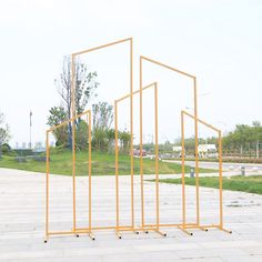 three wooden frames with arrows pointing in different directions on the same side, and an empty parking lot behind them