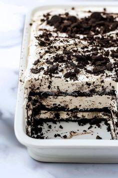 a cake with white frosting and chocolate sprinkles in a baking dish