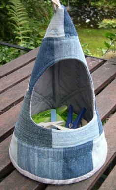 a blue and white cat bed sitting on top of a wooden table next to trees