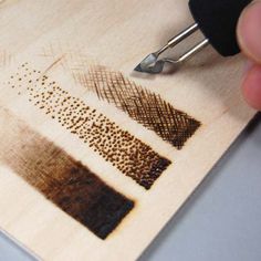 a person is using a pen to draw on wood