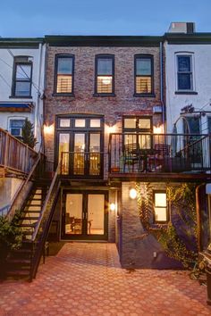 an apartment building with stairs leading up to the second floor and two story windows on each side