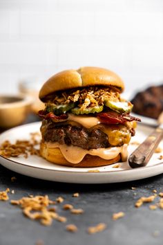 a hamburger with meat, cheese and pickles on a plate