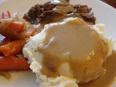 mashed potatoes, carrots and gravy on a plate with gravy