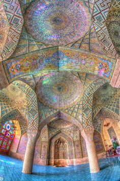 the inside of an ornate building with lots of windows and arches, all painted in different colors