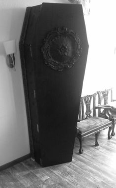 a large black cabinet sitting in the corner of a room next to a bench and chair