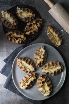 several waffles on a plate next to a rolling pin