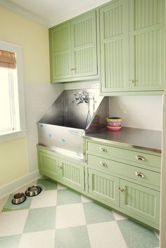 a kitchen with green cabinets and a checkered flooring pattern on the floor is shown