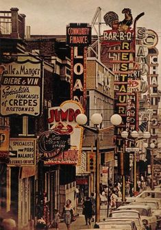 a city street filled with lots of traffic and tall buildings covered in neon signs on the side of it