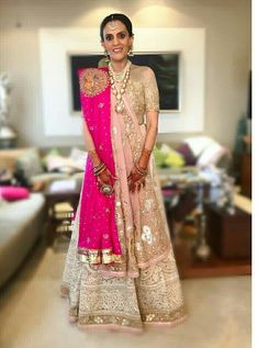 a woman in a pink and gold bridal outfit