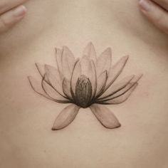 a woman's stomach with a flower tattoo on it