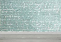 an empty room with a blue brick wall and wooden floor in front of it,