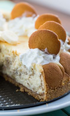 a piece of cheesecake on a plate with some whipped cream and cookies around it