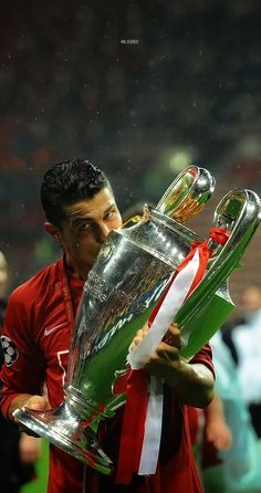 the soccer player is kissing the trophy on the field