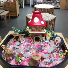 there is a mushroom house in the middle of a table with many toys on it