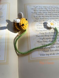 an open book with two crocheted flowers on it and a string attached to the page