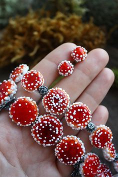 a hand holding several red and white beads