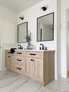 a bathroom with two sinks and mirrors on the wall