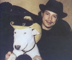 a man holding a dog wearing a cowboy hat