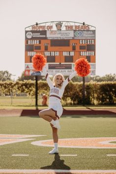 a cheerleader is performing on the football field with her pom - poms