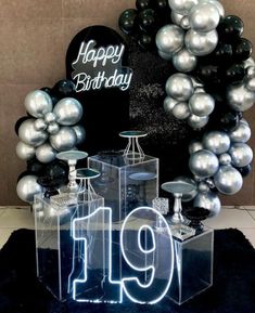 a table topped with balloons and a sign that says happy birthday to the 19 year old