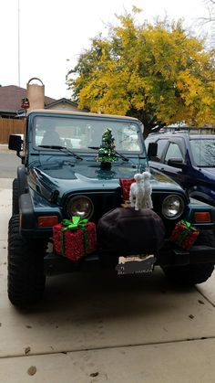 a jeep decorated for christmas with presents on the hood