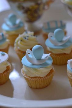 cupcakes decorated with blue and white icing on a plate