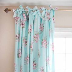 the curtain is hanging in front of the window with pink flowers and green leaves on it