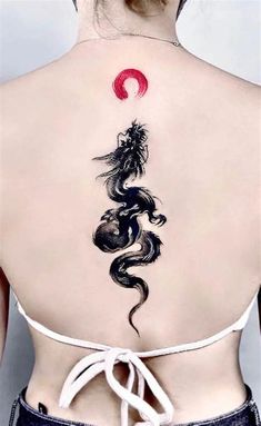 the back of a woman's neck with a dragon tattoo on it