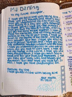 an open notebook with writing on it and some words written in blue ink next to each other