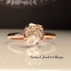 a close up of a ring with an oval shaped diamond on it's side