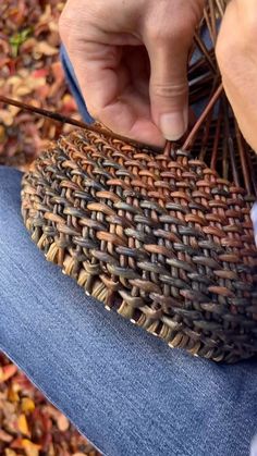 a person is weaving something on top of a blue chair with two needles in it