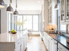 a large kitchen with white cabinets and stainless steel appliances in it's center island