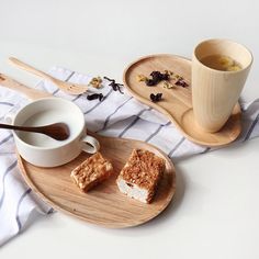 two plates with desserts on them next to a cup of tea and saucer