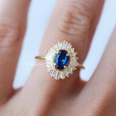 Beautiful Art Deco Sapphire Ring ►Base Metal: Sterling Silver (S925) ►Plating: 14K Yellow Gold Vermeil ►Accented With Simulated Diamonds Main Stone: Sapphire Color: Blue Gemstone Creation: Lab-Created Stone Shape: Oval Cut Gem size: 7.0 x 5.0 mm Carat Weight: 0.76 ct. (Approx.) ►Can be customized. Please contact us if you have special requests. ►Please be aware that plated jewelry can wear off over time, if this is a concern we would suggest going with the sterling silver or solid gold jewelry o Sapphire Cluster Ring In Cubic Zirconia For Wedding, Sapphire Cubic Zirconia Cluster Ring For Wedding, Classic Blue Halo Ring As A Gift, Classic Blue Halo Ring For Gift, Classic Blue Cluster Ring With Halo, Blue Sapphire Ring In 14k Gold For Wedding, Sapphire Cluster Ring In 14k Gold For Wedding, Sapphire Cluster Ring 14k Gold For Wedding, Blue Sapphire Ring 14k Gold For Wedding