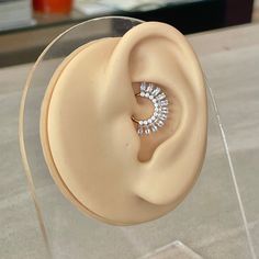 a pair of earring sitting on top of a glass display case with clear acrylic