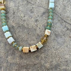 You'll give off nothing but good vibes with the subtle hues in this mixed media natural stone beaded necklace. This piece is perfect worn alone or in a layered #neckmess. Soft tones of sea, sand, and sunshine in geometric shapes of cubes, spheres, and cylinders blend beautifully in this mixed-media necklace. The vibrant gold plated brass spacer beads add contrast and space to the pale hues of amazonite, aventurine, and citrine beads creating a subtle drama inviting a closer look. Citrine Aventur Adjustable Gemstone Beaded Necklace For Everyday, Adjustable Gemstone Beaded Necklace For Beach, Handmade Adjustable Amazonite Beaded Necklaces, Handmade Adjustable Amazonite Beaded Necklace, Adjustable Amazonite Gemstone Beaded Necklace, Amazonite Gemstone Beaded Necklaces With Round Beads, Amazonite Gemstone Beaded Necklace With Round Beads, Amazonite Gemstone Beaded Necklace, Bohemian Amazonite Single Strand Beaded Necklace